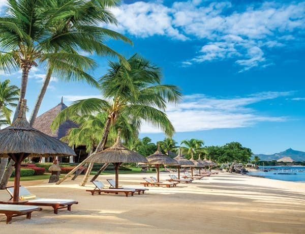Beach view of The Oberoi Mauritius with sunbeds and parasols