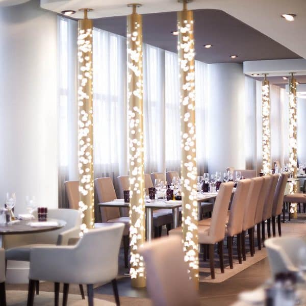 View of the restaurant at the Pullman Paris La Defense with lights on the pillars