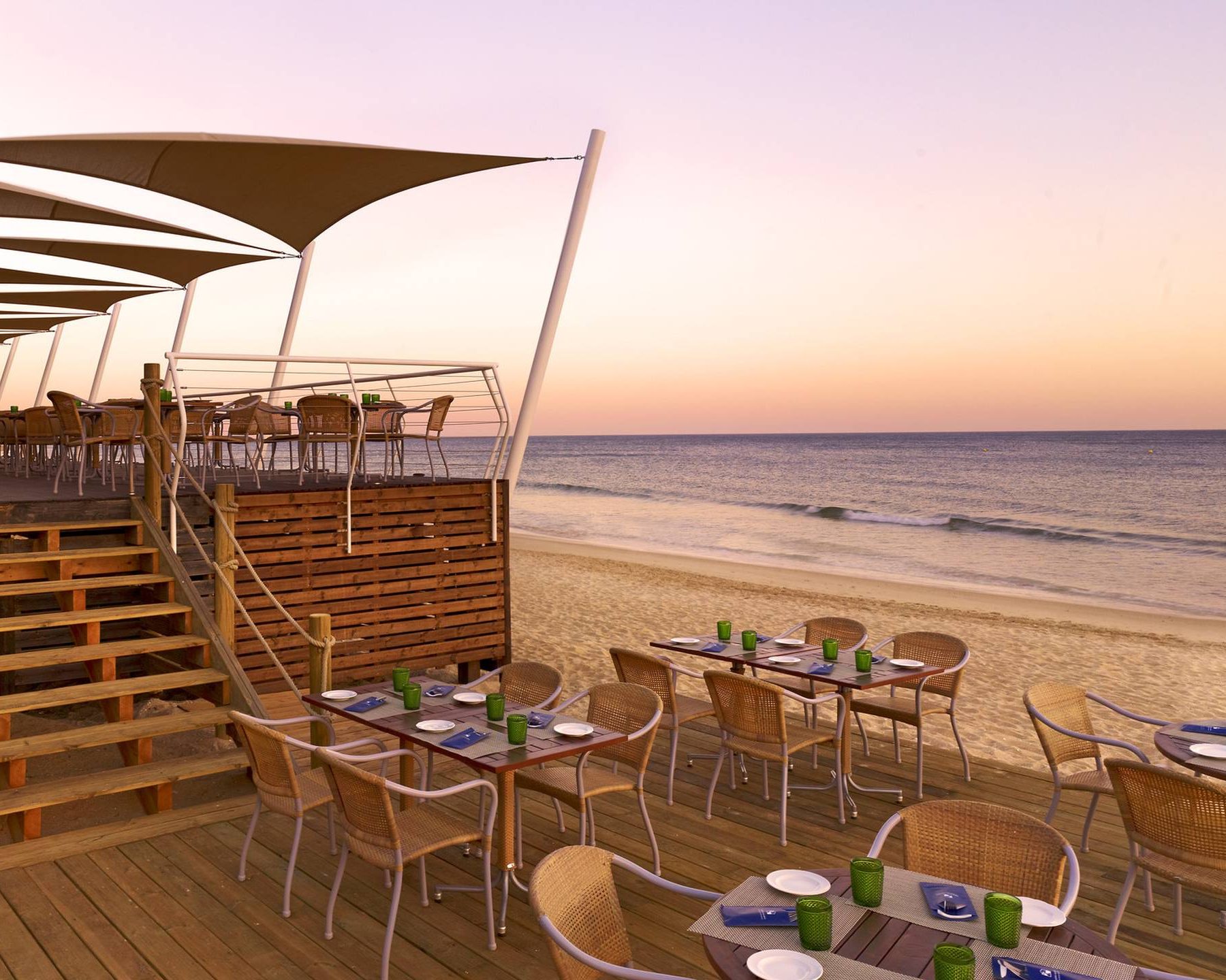 View of the beach and dining at dusk at Pine Cliffs, A Luxury Collection Resort in Algarve in Portugal
