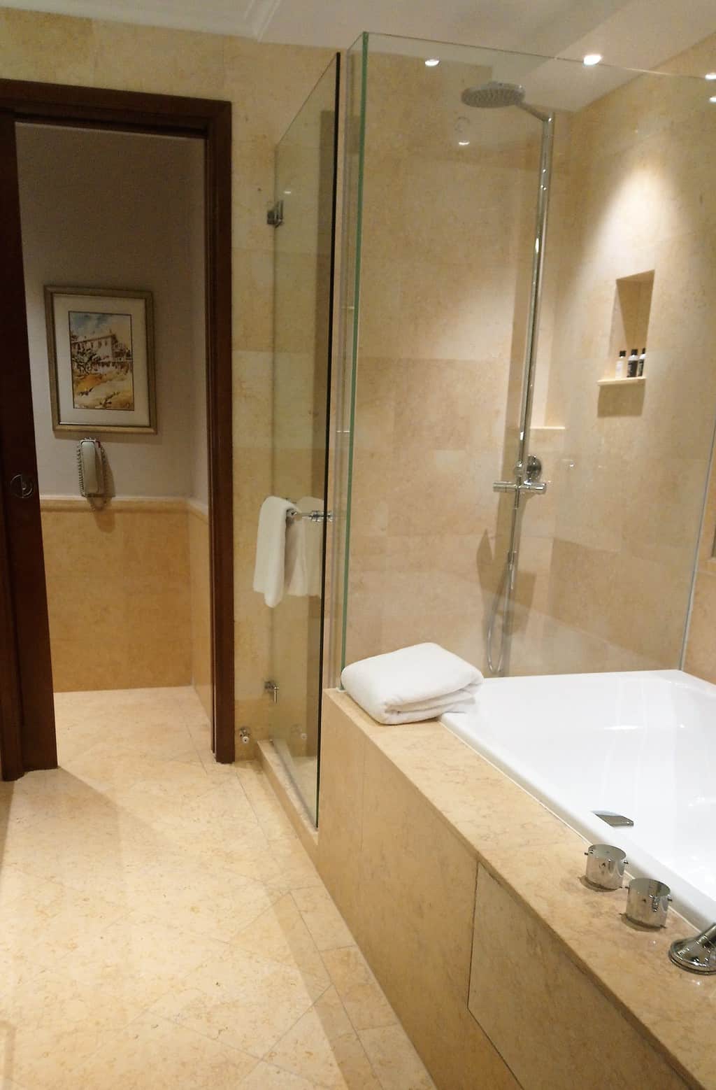 View of the bath and shower in the bathroom of a Premier Courtyard Room at The Fullerton Hotel in Singapore