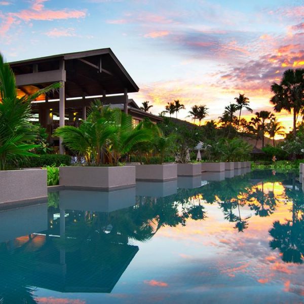 The Olympic-sized swimming pool at Kempinski Seychelles Resort at dusk